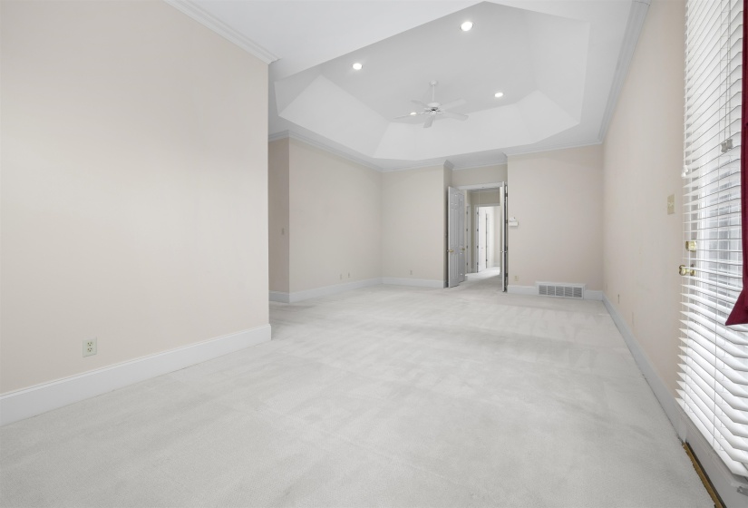Spare room with ornamental molding, carpet floors, a tray ceiling, recessed lighting, and a ceiling fan