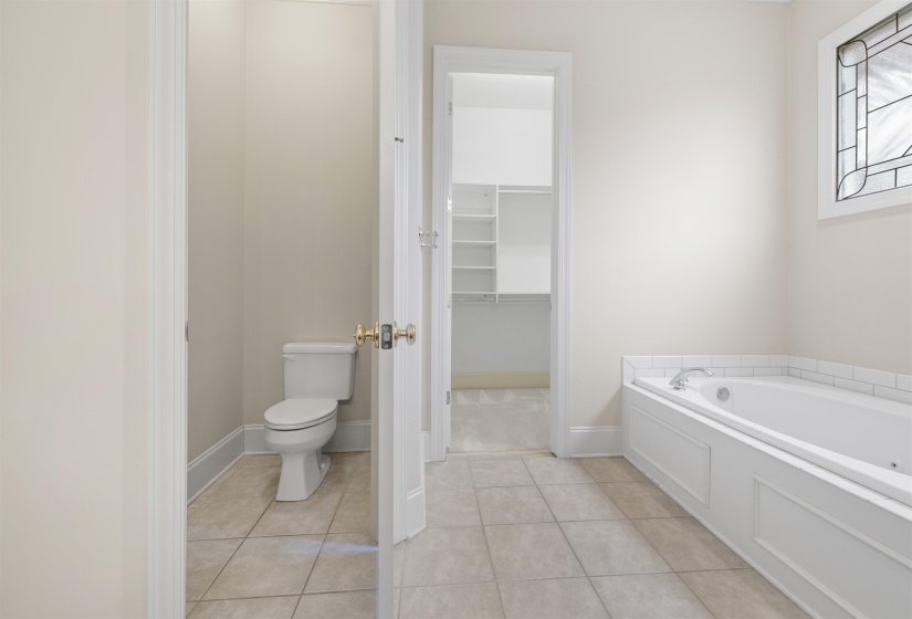 Full bathroom with a bath, a walk in closet, and light tile patterned floors
