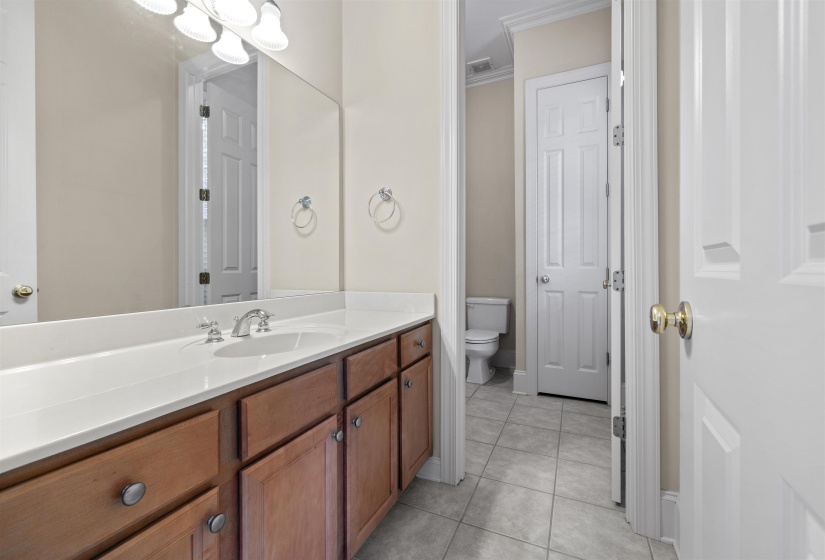Full bathroom featuring vanity, crown molding, and light tile patterned floors
