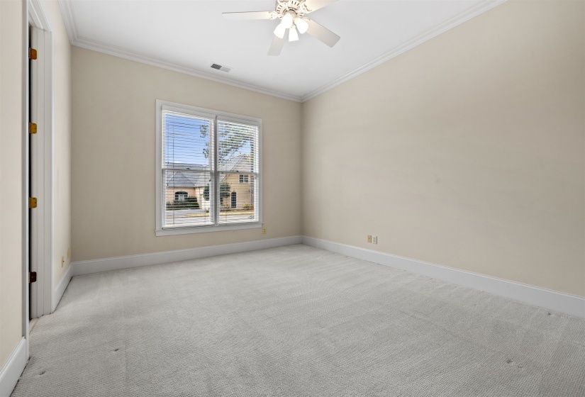 Empty room with crown molding, carpet floors, and ceiling fan