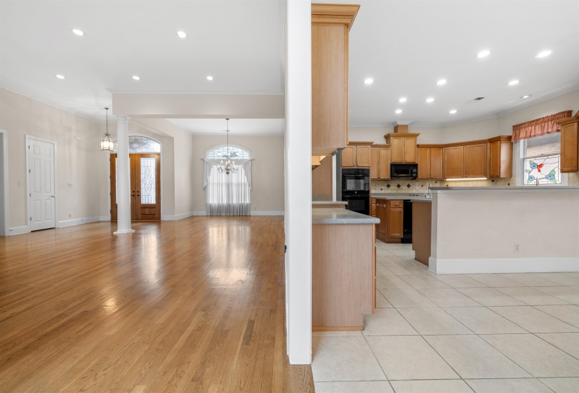 Kitchen featuring healthy amount of natural light, open floor plan, decorative backsplash, hanging lights, and ornamental molding