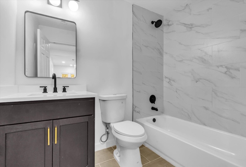 Bathroom featuring vanity, washtub / shower combination, and light tile patterned floors