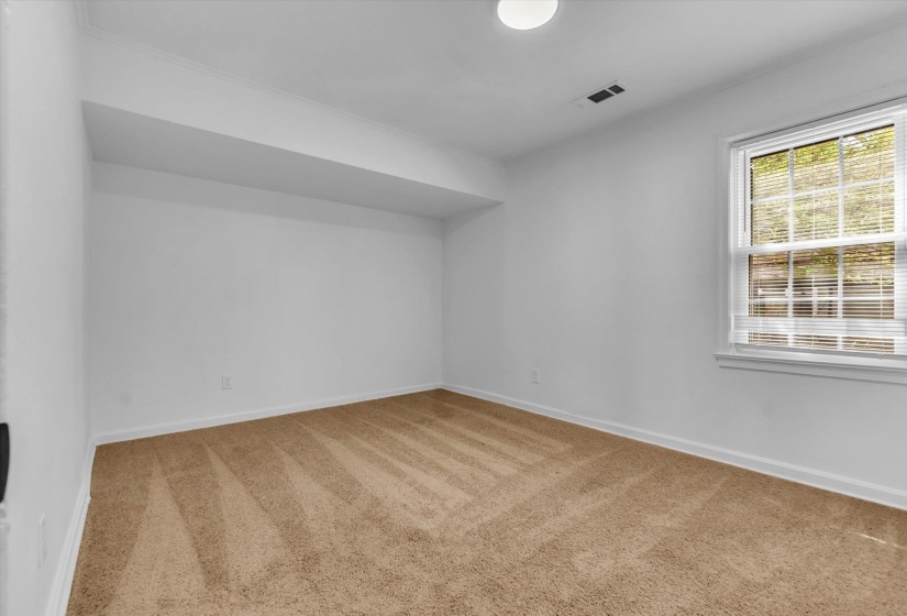 Spare room featuring light colored carpet and baseboards