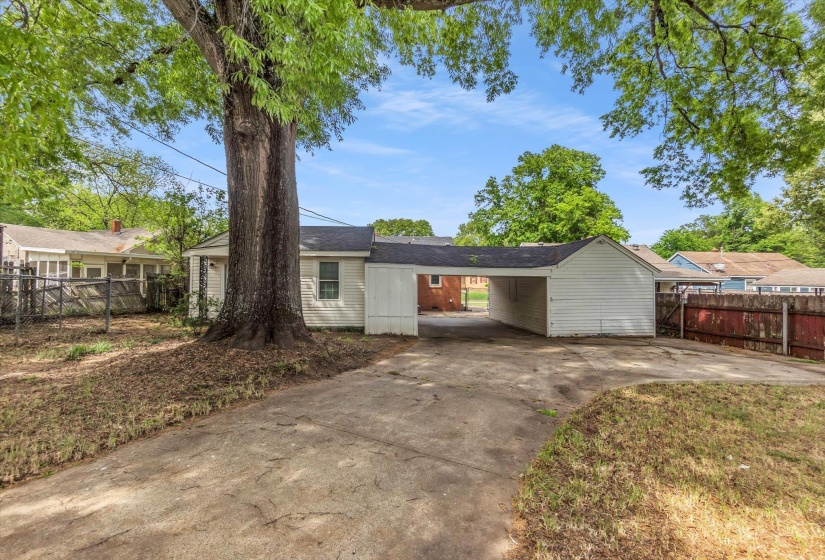 Single story home with concrete driveway and a carport
