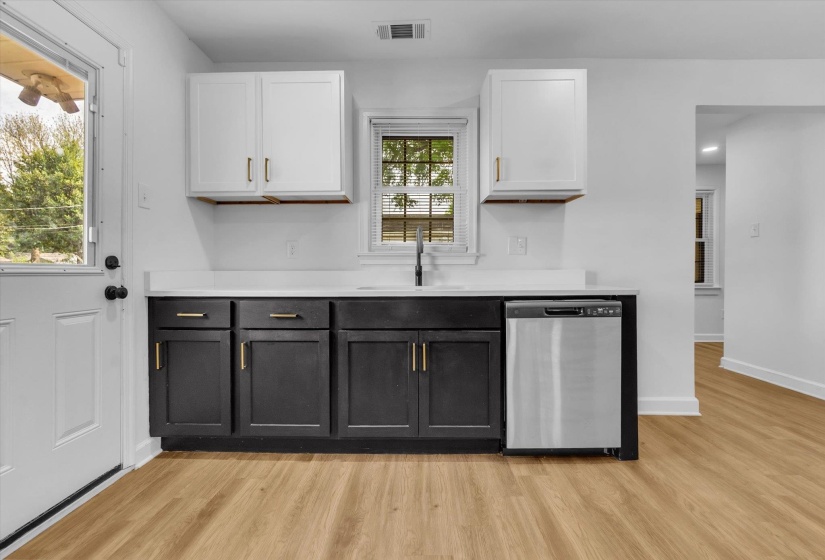 Two tone kitchen with dual tone cabinets, stainless steel dishwasher, light wood-style flooring, and recessed lighting