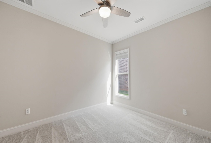 Empty room with crown molding, light colored carpet, and ceiling fan