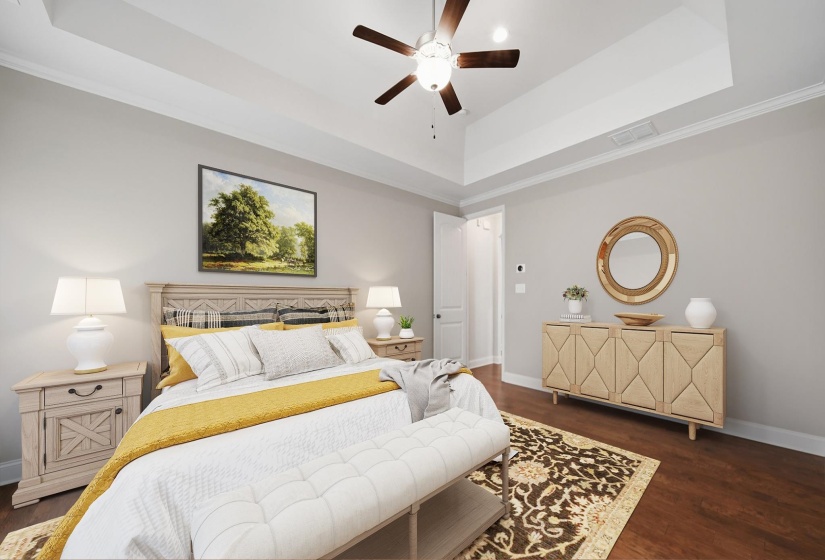 Bedroom featuring a tray ceiling, ornamental molding, dark wood finished floors, and a ceiling fan