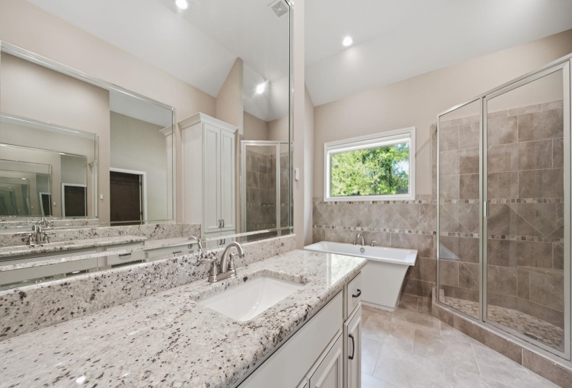 Full bathroom with a shower stall, vanity, lofted ceiling, a soaking tub, and tile walls