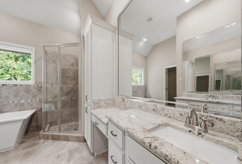 Full bathroom with a shower stall, vanity, a freestanding tub, and vaulted ceiling
