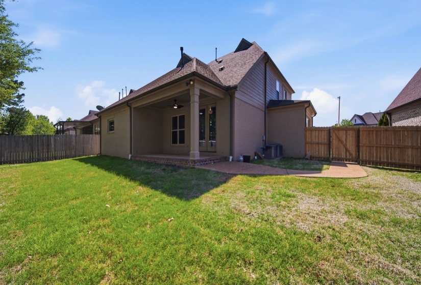 Back of property with a patio area, a fenced backyard, ceiling fan, brick siding, and roof with shingles