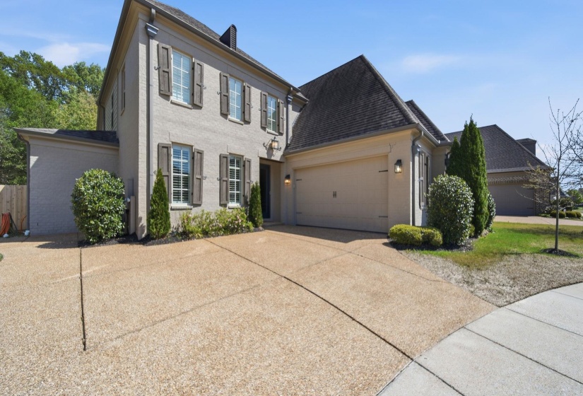 View of front of property with concrete driveway, a garage, and brick siding
