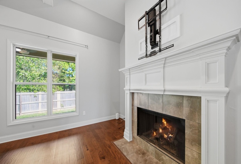 Unfurnished living room with a fireplace, dark wood-type flooring, and vaulted ceiling