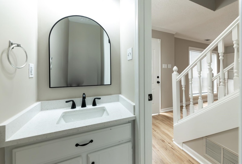 Bathroom with crown molding, vanity, and light wood-type flooring