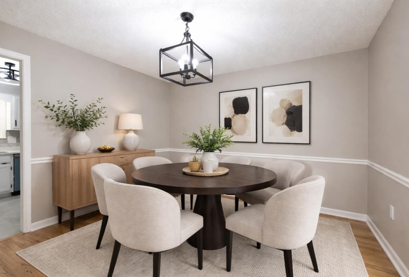 Dining area featuring light wood finished floors, suspended lighting, and a textured ceiling