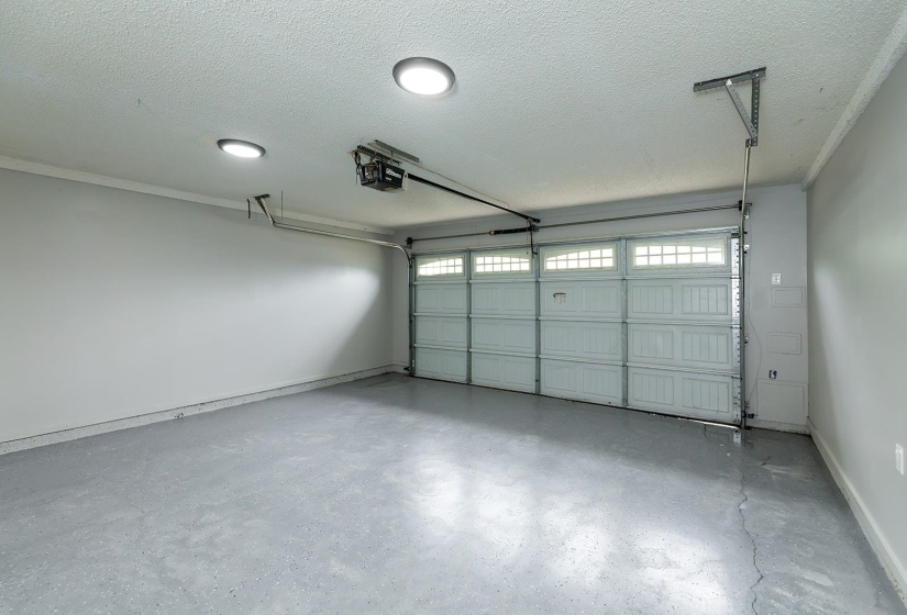 Garage featuring baseboards and a garage door opener