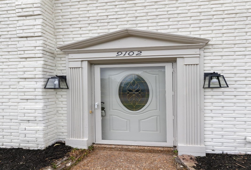 View of exterior entry featuring brick siding