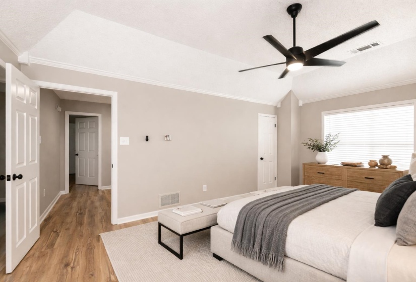 Bedroom with lofted ceiling, crown molding, light wood-style floors, and ceiling fan
