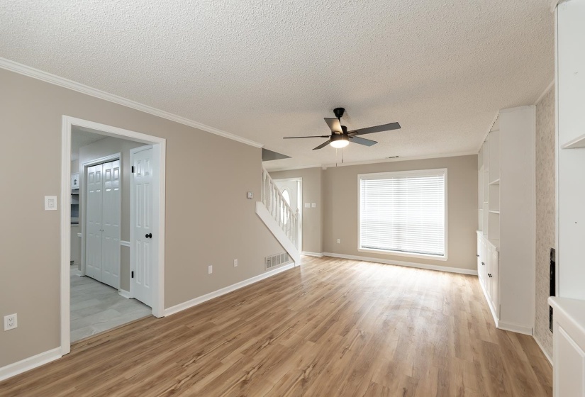 Spare room with ceiling fan, light wood-style flooring, a textured ceiling, and crown molding