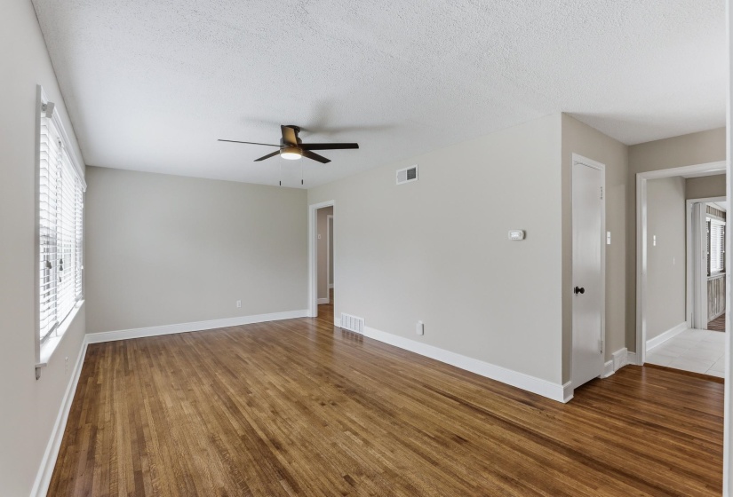 Spare room featuring dark wood-type flooring, a textured ceiling, and ceiling fan