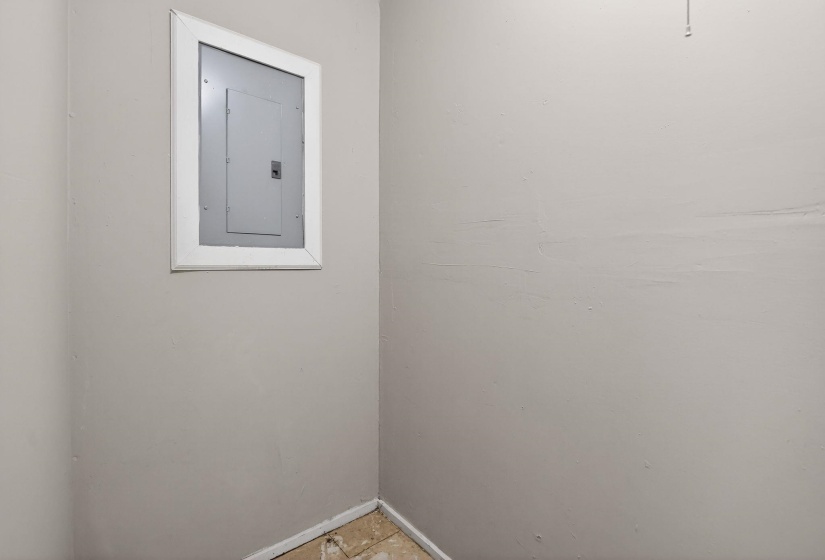 Empty room featuring electric panel and baseboards