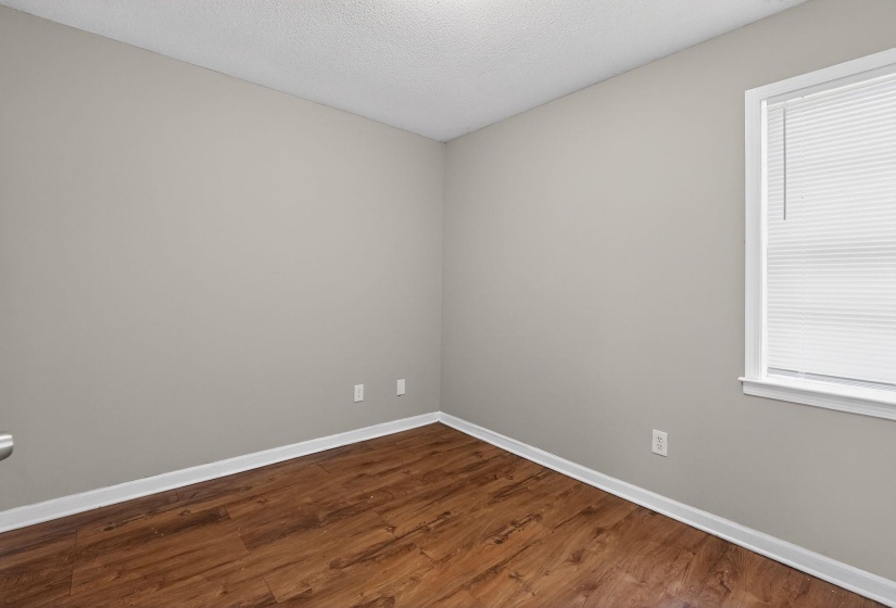 Spare room featuring dark wood finished floors and a textured ceiling