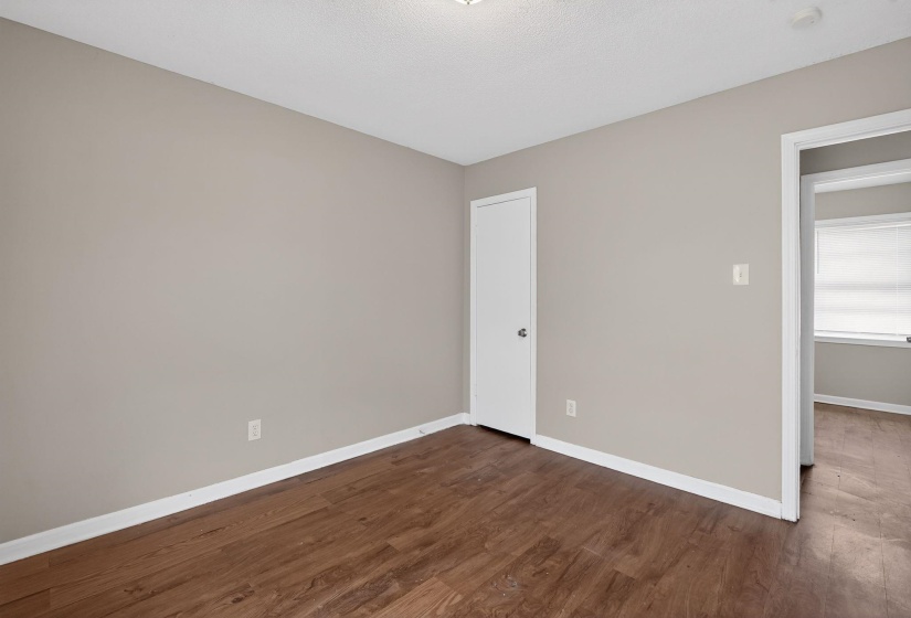 Spare room with baseboards and dark wood-style flooring