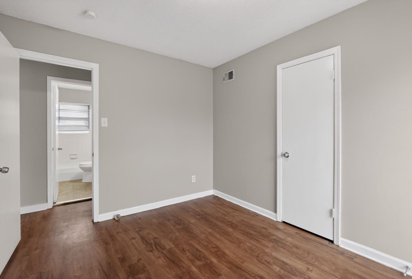 Unfurnished bedroom featuring baseboards and dark wood-style floors