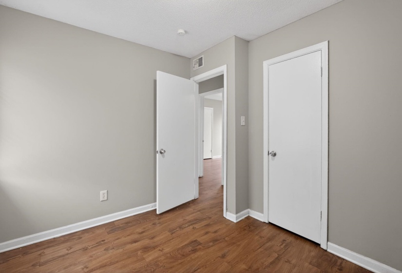 Unfurnished bedroom featuring dark wood-type flooring and a textured ceiling