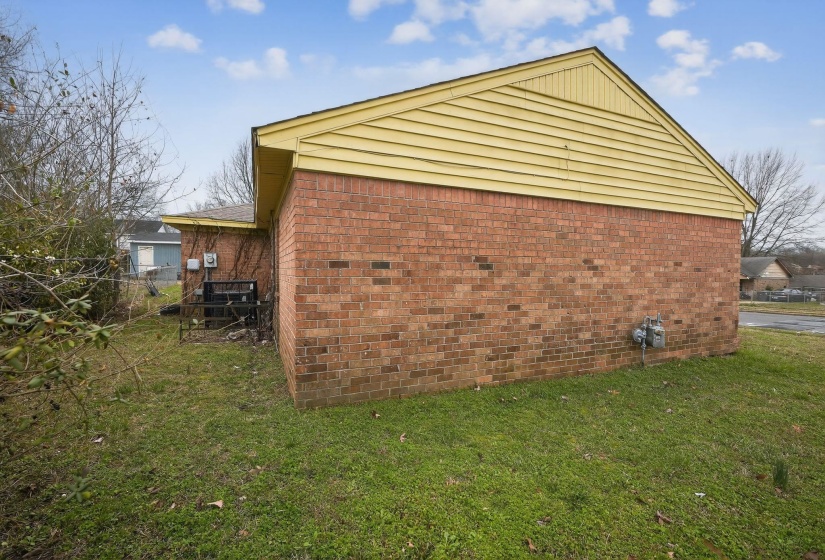 View of side of home featuring brick siding and a cooling unit