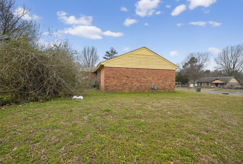 View of home's exterior featuring brick siding and a lawn