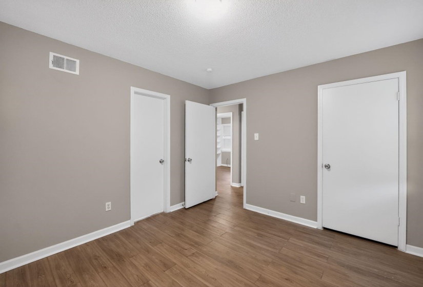 Unfurnished bedroom featuring wood finished floors and a textured ceiling