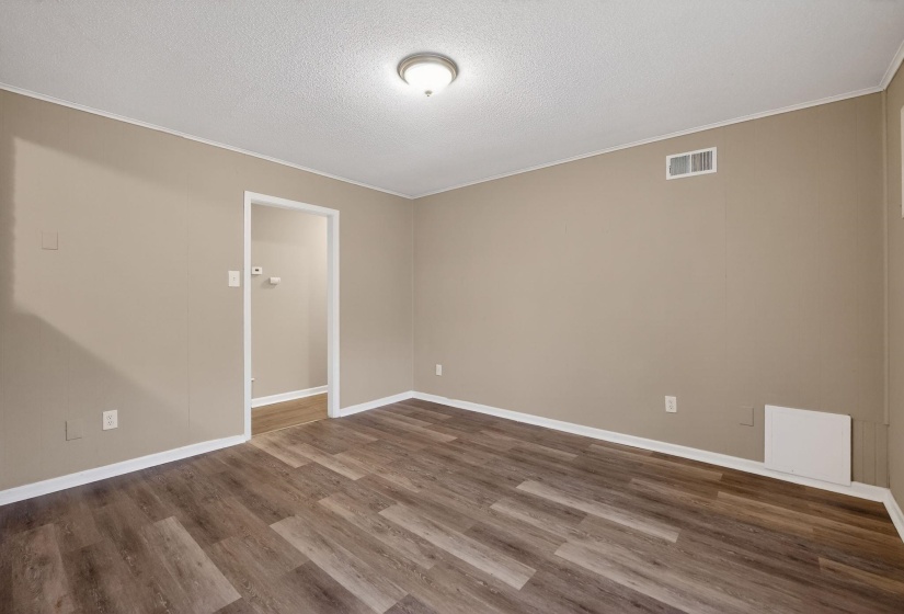 Spare room with dark wood-style floors, a textured ceiling, and ornamental molding