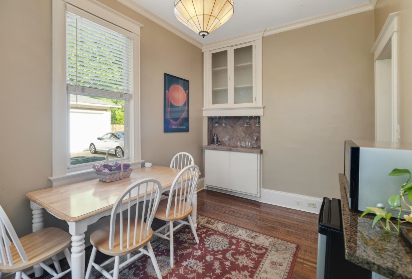 Dining room with ornamental molding and dark wood-style flooring