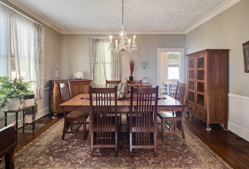 Dining space with a chandelier, crown molding, dark wood finished floors, and a textured ceiling