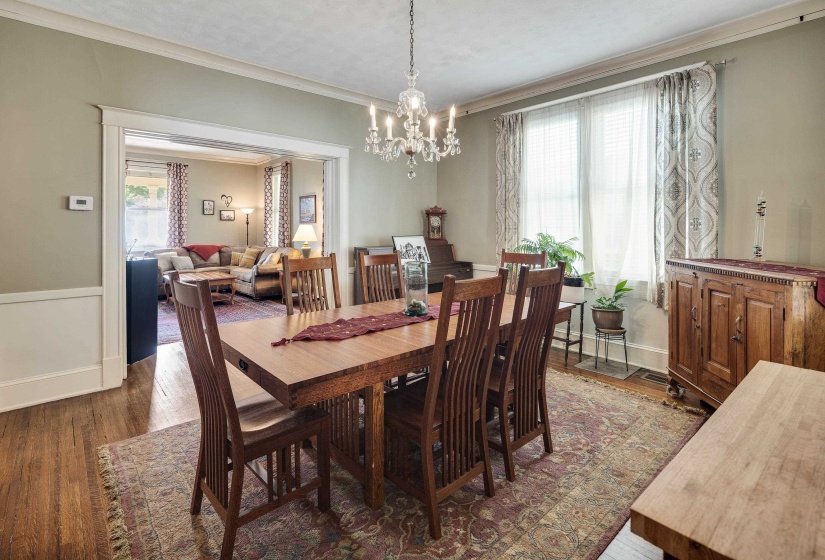 Dining space with ornamental molding, wood finished floors, and a chandelier
