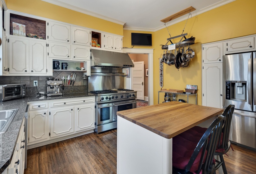 Kitchen featuring open shelves, stainless steel appliances, tasteful backsplash, dark wood-type flooring, and ornamental molding