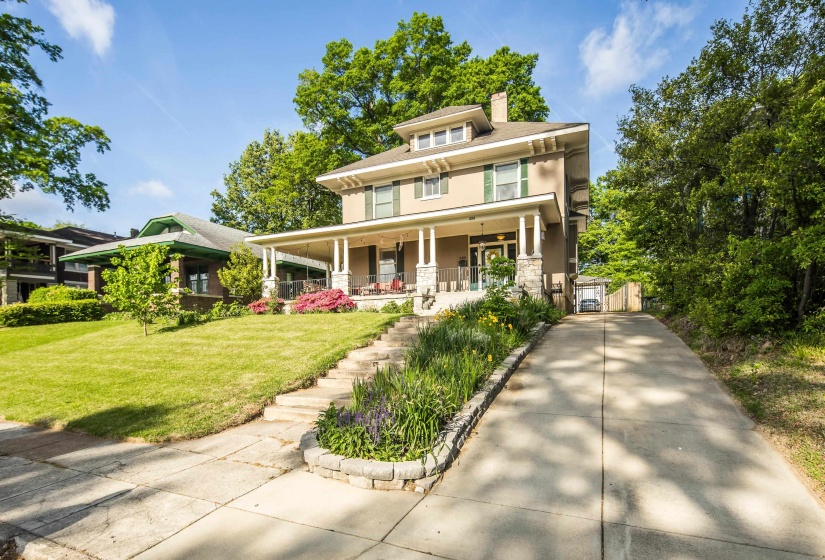 Traditional style home with covered porch, a chimney, a front lawn, and a gate