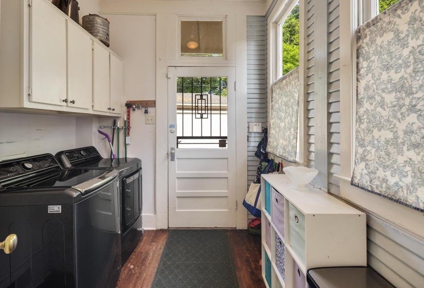 Laundry area with washing machine and dryer, dark wood finished floors, and cabinet space