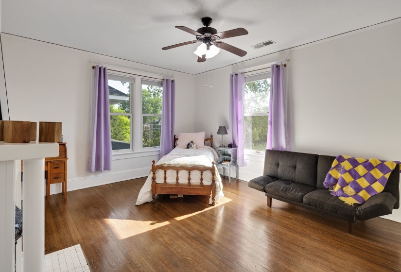 Bedroom featuring hardwood / wood-style floors, a ceiling fan, and multiple windows