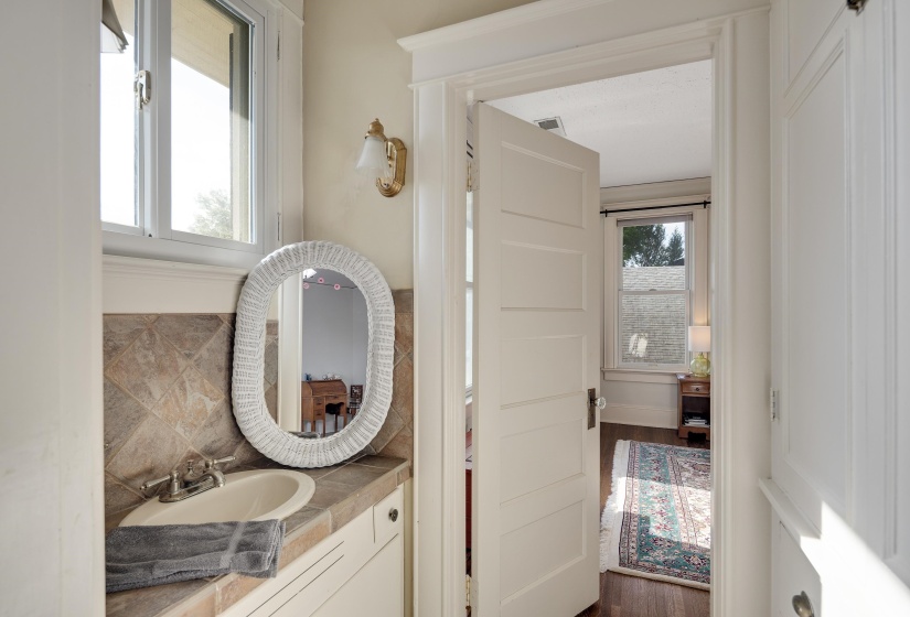 Half bathroom featuring vanity and dark wood-style flooring
