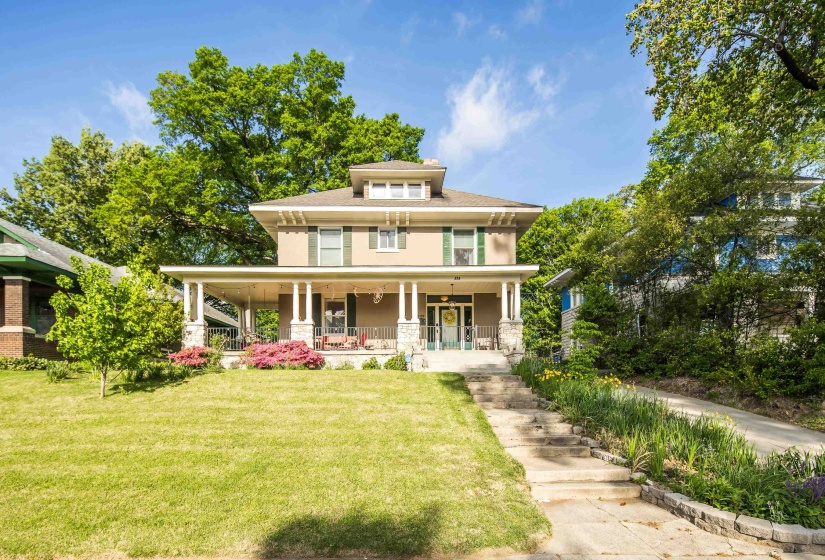Traditional style home with a porch, a front yard, and a shingled roof