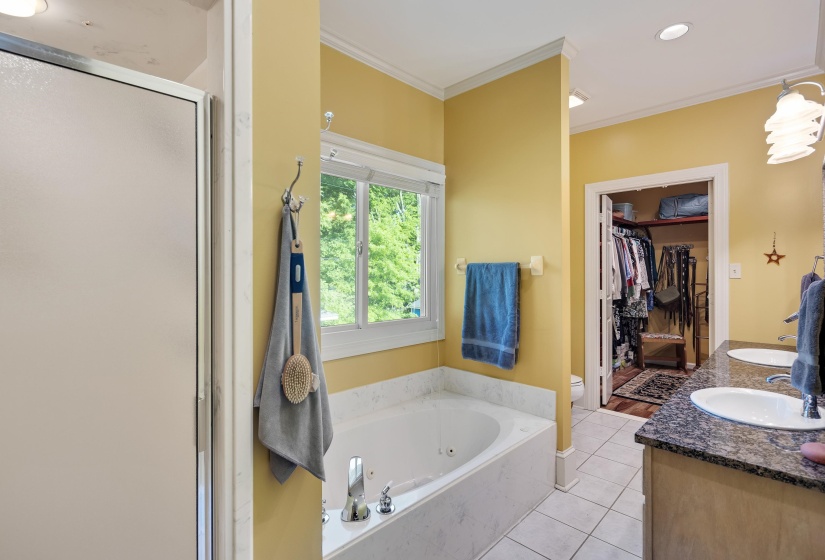 Bathroom with a walk in closet, double vanity, ornamental molding, a stall shower, and light tile patterned floors