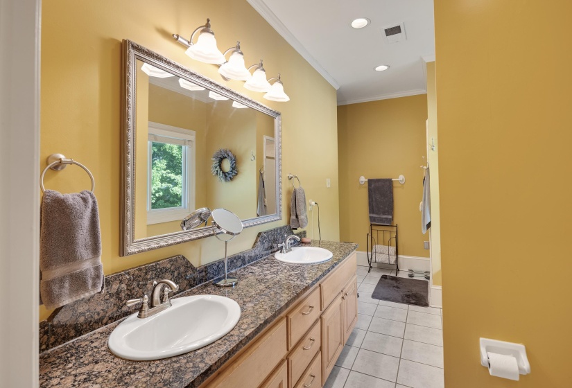 Bathroom with light tile patterned floors, crown molding, double vanity, and recessed lighting