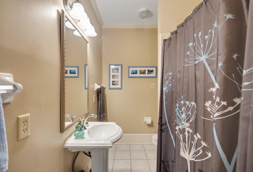 Full bath with ornamental molding, light tile patterned floors, and curtained shower
