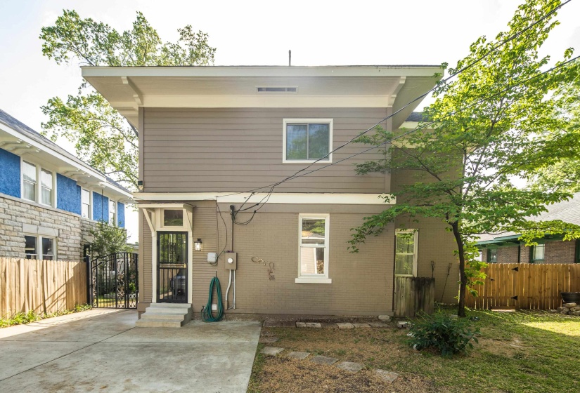 Rear view of property with a gate and brick siding