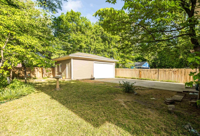 Fenced yard with an outdoor structure and a garage