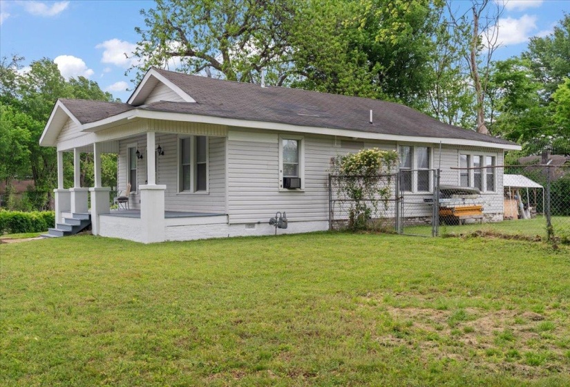 Rear view of property featuring crawl space, covered porch, a gate, and a shingled roof