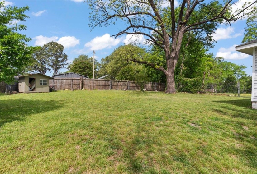 Fenced backyard with an outdoor structure