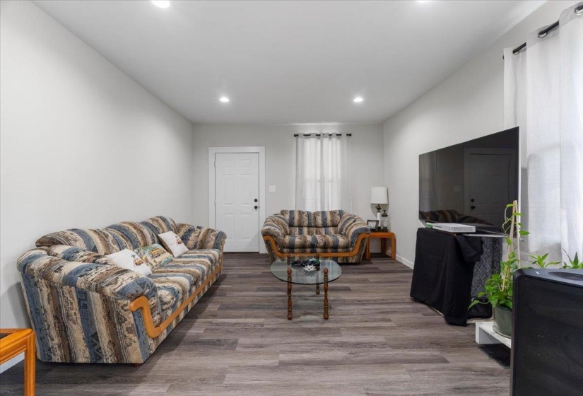 Living area with wood finished floors and recessed lighting