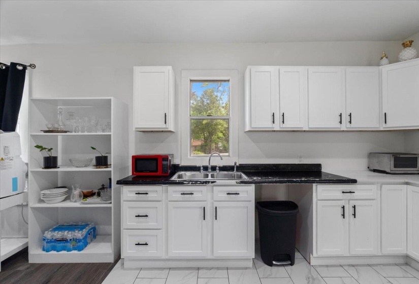 Kitchen featuring white cabinetry and dark stone counters